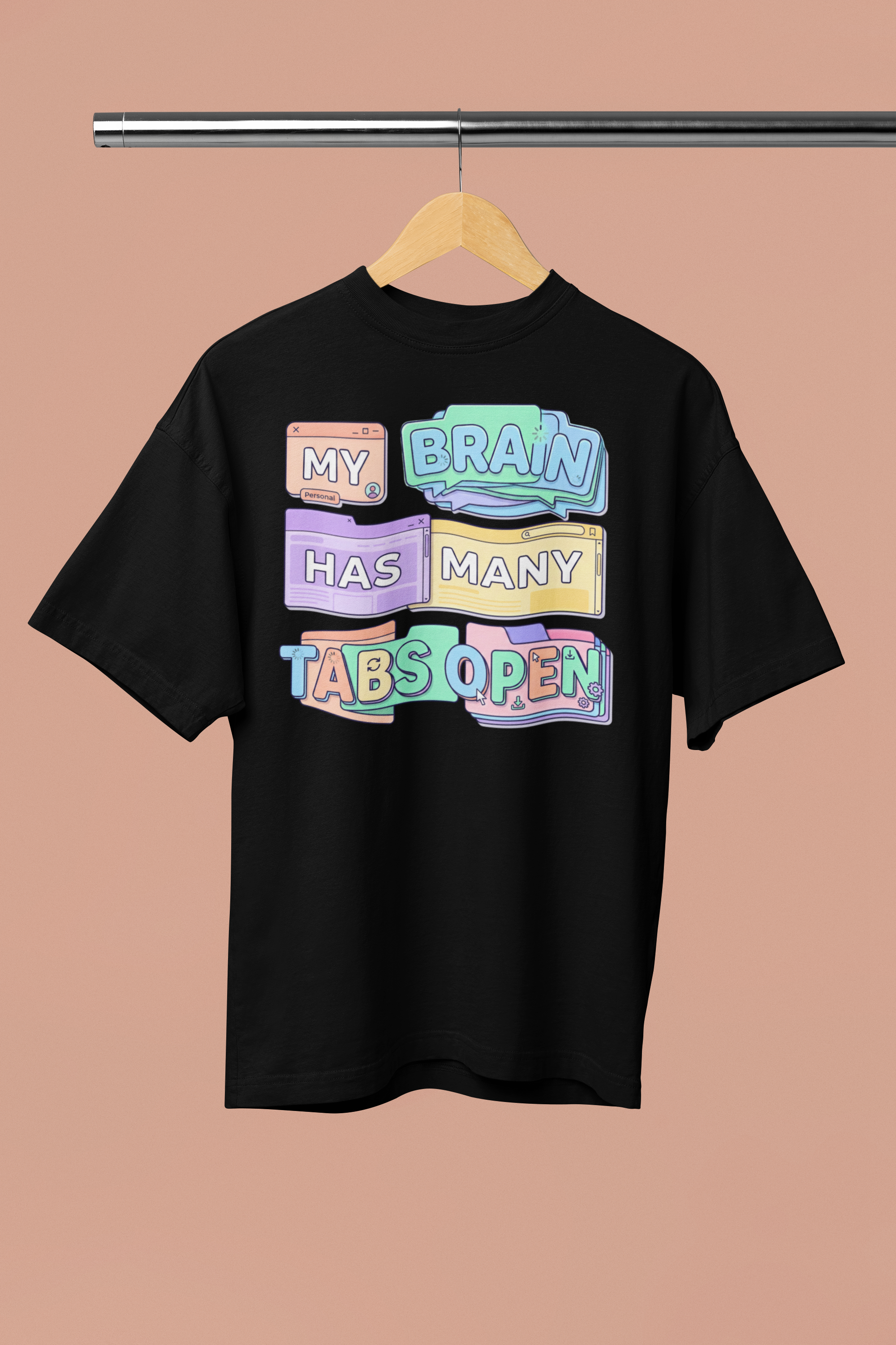 Black t-shirt with colorful text design on a hanger against a beige background
