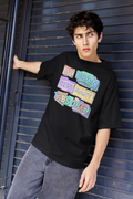 Person wearing a black t-shirt with colorful text design against a blue metal background