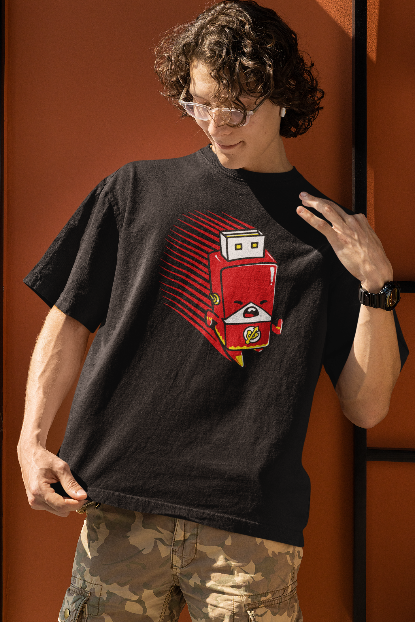 Person wearing a black t-shirt with a red and white graphic design on an orange background