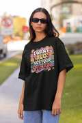 Person wearing a black t-shirt with colorful text on a street background