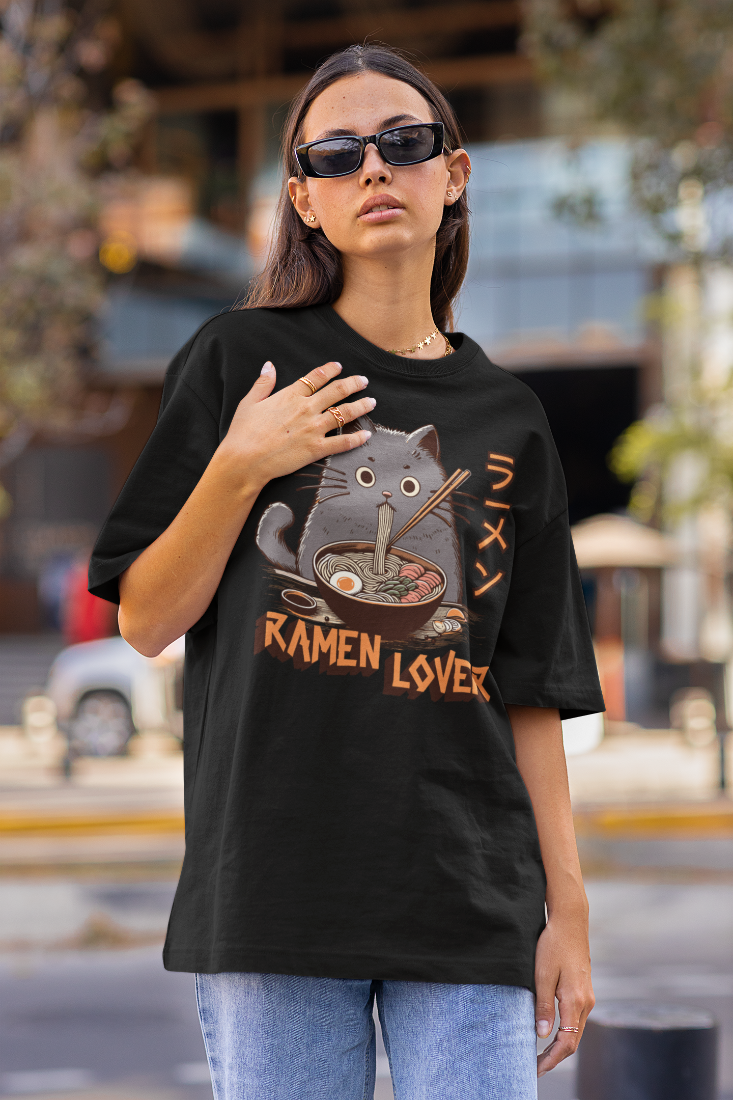 Person wearing a black t-shirt with a graphic design and text, standing outdoors.