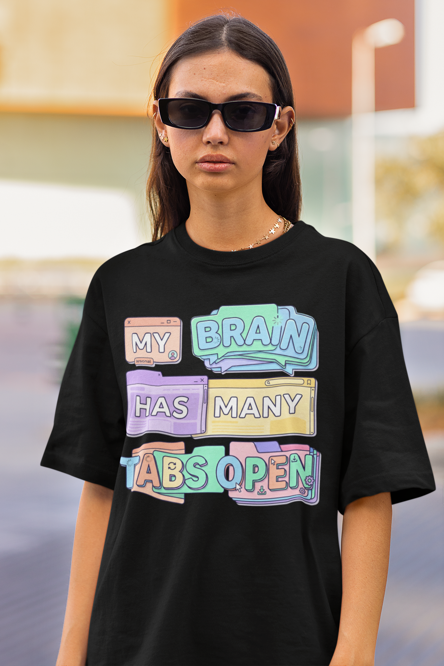 Person wearing a black t-shirt with colorful text design outdoors.